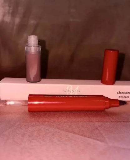 A rose gold liquid lip gloss tube and its applicator pen, both resting on a white box with the brand name 'MUSCA' partially visible.